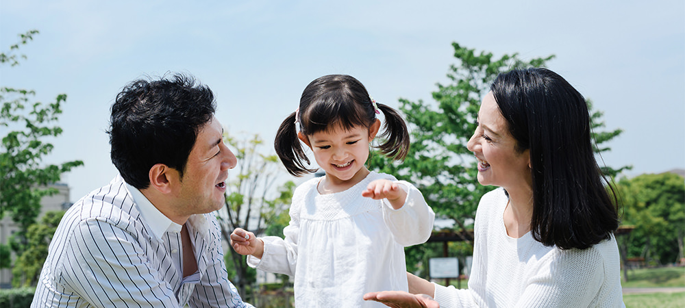 公園で両親の間にいる子供の写真