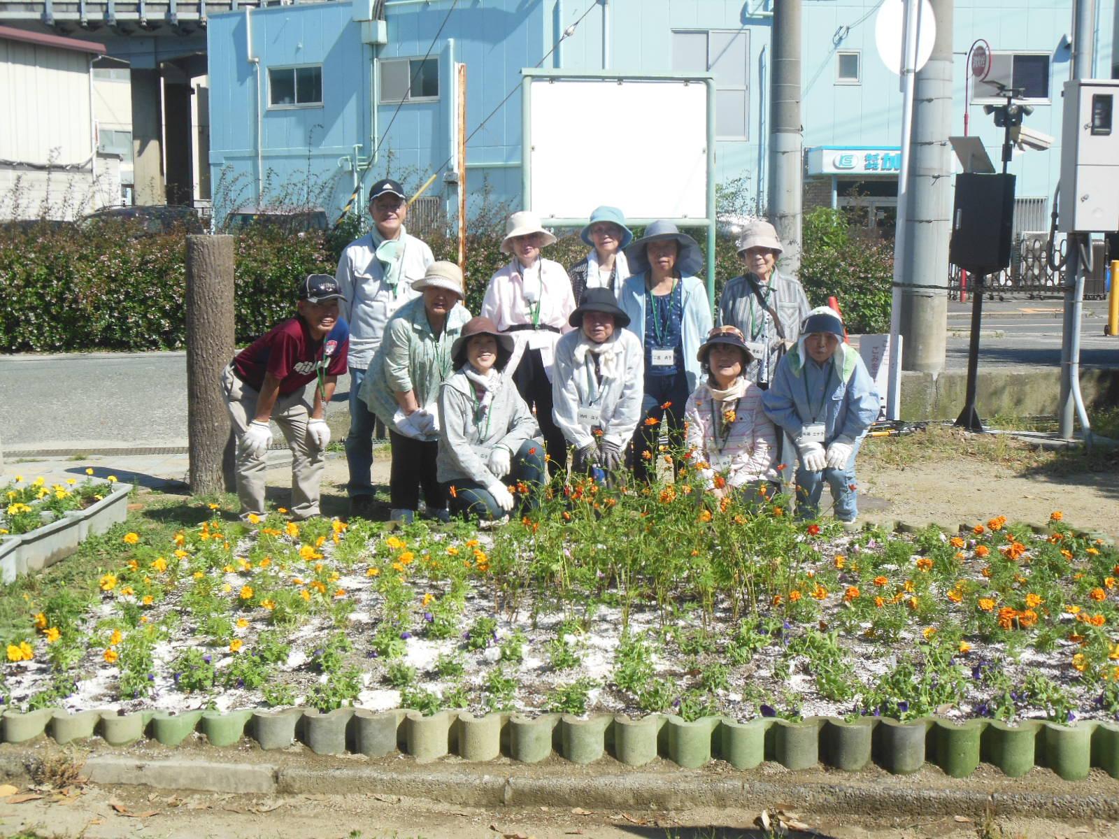 別府公園の花壇の前でボランティアの方々の集合写真