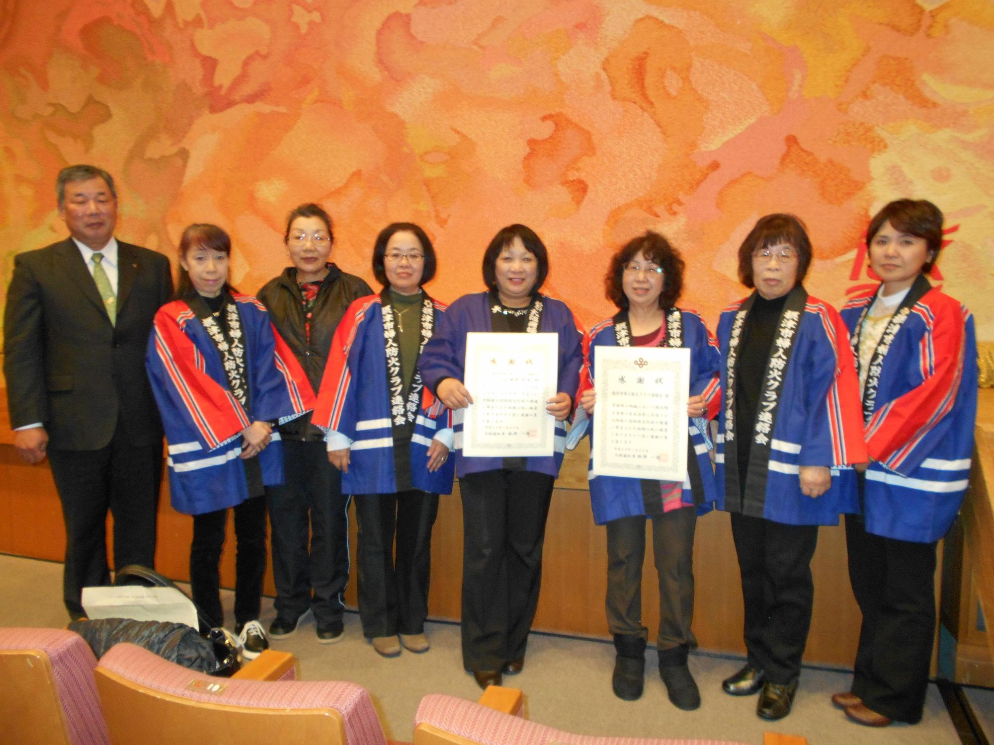 消防長と、摂津市婦人防火クラブ連絡会からの出席者7名の写真