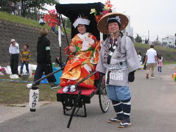 花嫁さんが人力車に乗って会場に登場している写真