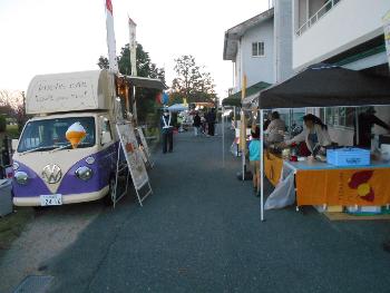 キッチンカーやテントの中で準備を進める人々