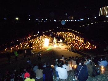 階段からろうそくに彩られたステージを眺めている