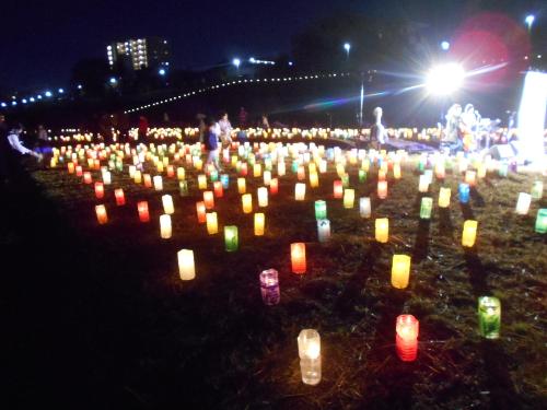 中に入っているろうそくの明かりに照らされたカラフルなペットボトルが彼方まで広がっている