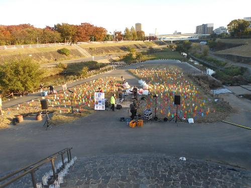 まだ明るいステージの周りにたくさんのカラフルなろうそく入りのペットボトルが並べられている