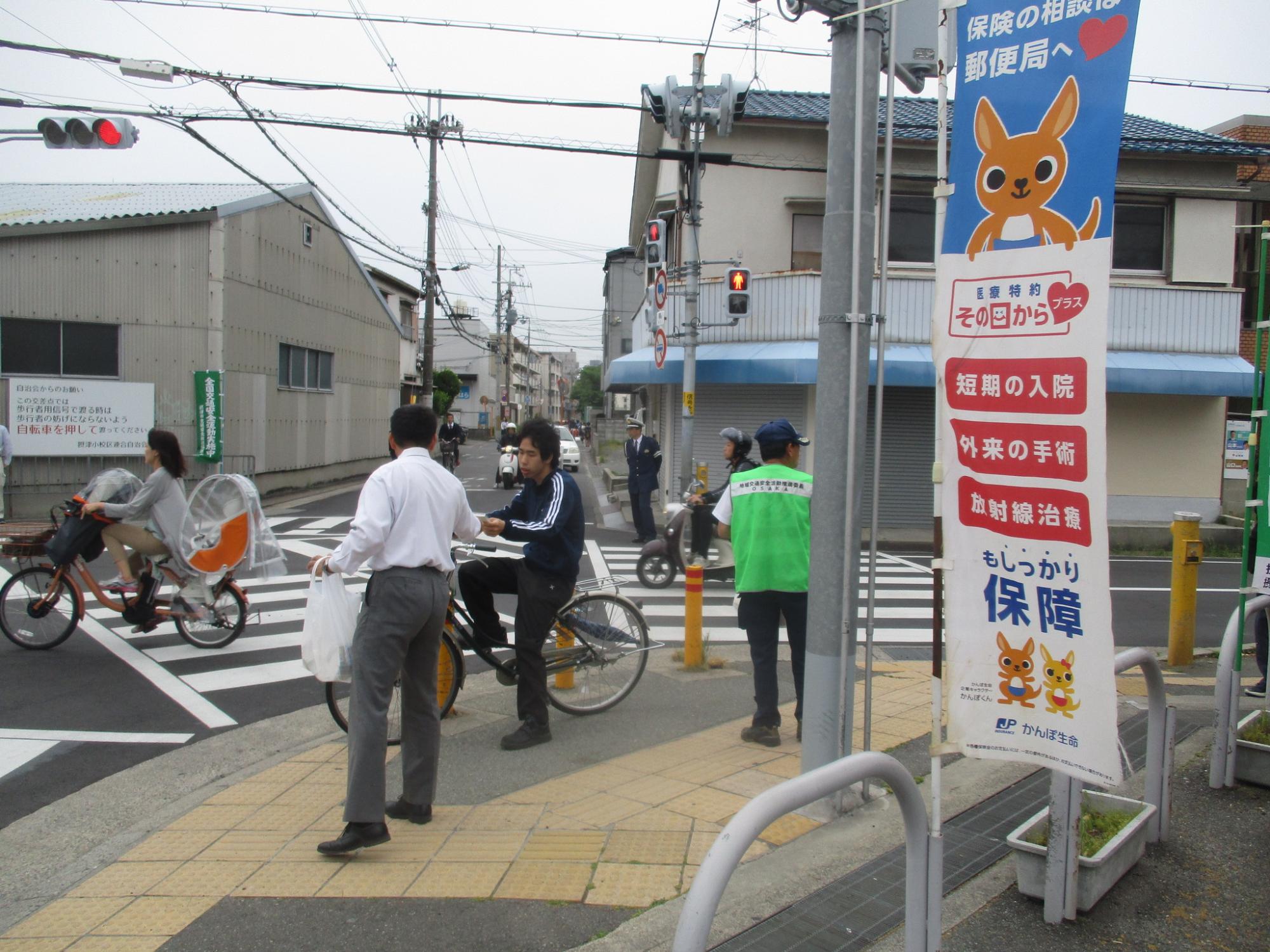 摂津郵便局前での自転車利用者指導の様子の写真